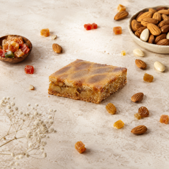Gâteau aux amandes et fruits confits, entouré d'amandes et de fruits conf